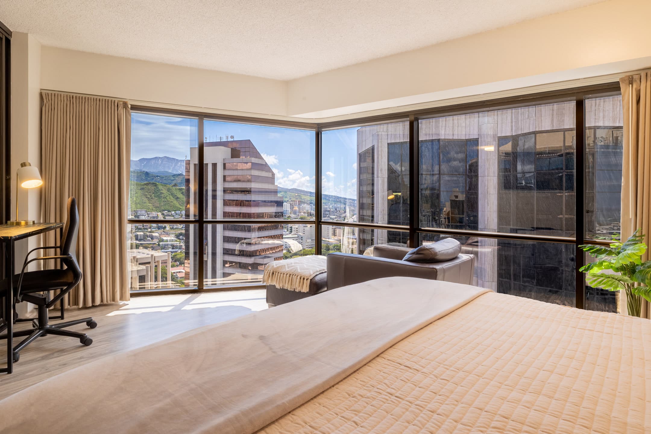 Guest room at Bishop Suites with a desk and downtown Honolulu views
