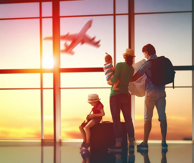 A family with luggage waiting together at the airport before their flight